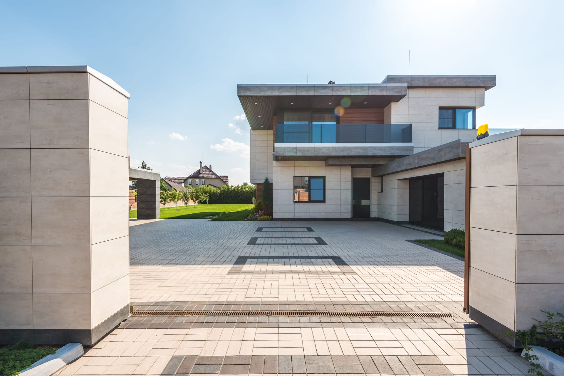 A lush, freshly landscaped backyard with a manicured lawn, stone patio, and layered plantings.