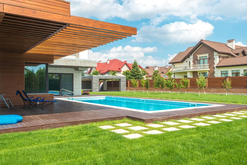 Sunlit backyard pool beside a pergola
