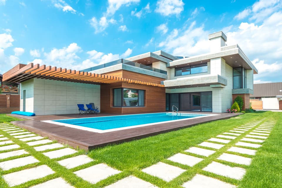 A contemporary home with a crystal-clear pool and lush lawn.